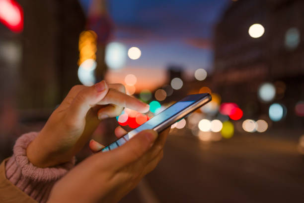 istock Close-up hand using phone in night time on street 899227102