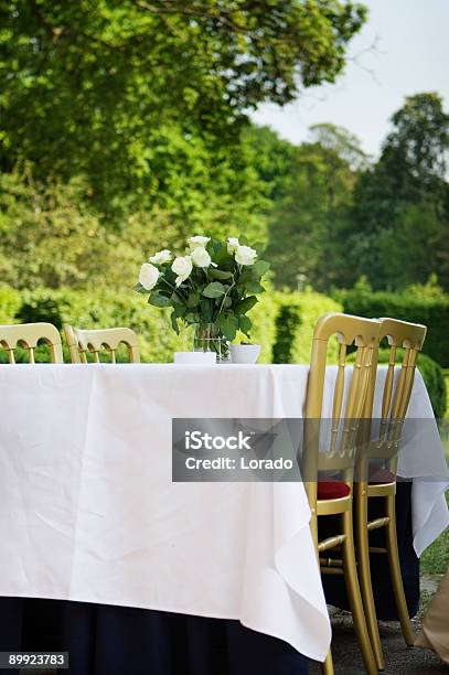 Foto de Mesa Com Rosas Em Um Jardim e mais fotos de stock de Café - Casa de comes e bebes - Café - Casa de comes e bebes, Almoço, Assento