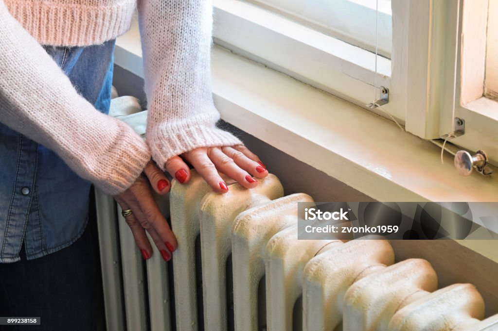 Winter time in a warm central heated room Old heavy duty radiator heats the room in best way Radiator - Heater Stock Photo