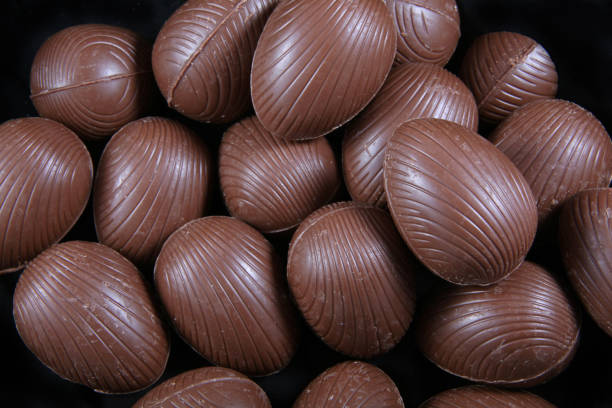 istock Close up of chocolate easter eggs, with the wrappers off ready to eat against a black background. 899242530