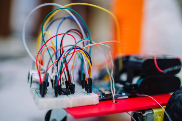 istock Macro photo of a little embedded systems breadboard with attached cables. White small breadboard with small electronics components and sensors on it. 899243770