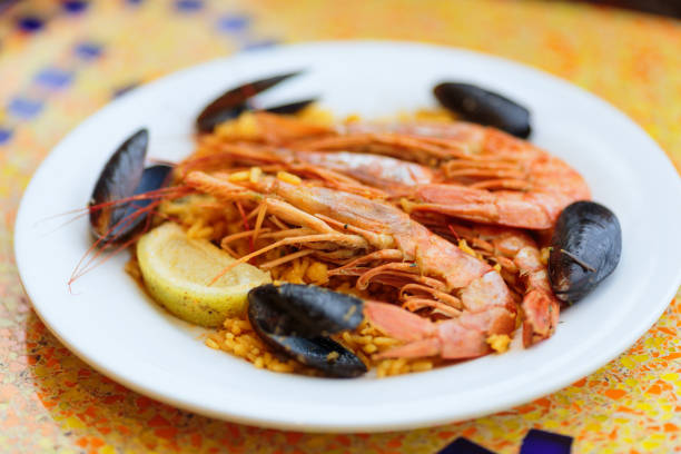 istock Paella. Rice with king prawns, mussels and lemon 899246804