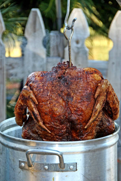 Delicious hot Deep Fried Turkey right out of the fryer Thanksgiving turkey coming out of the fryer golden brown and juicy crispy going to eat now deep fried photos stock pictures, royalty-free photos & images