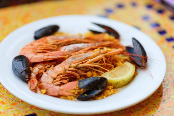 istock Paella. Rice with king prawns, mussels and lemon 899246920