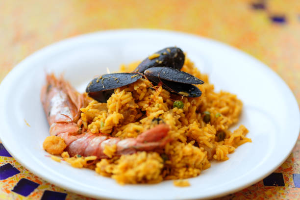 Paella. Rice with king prawns, mussels and lemon stock photo