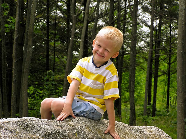 istock Smiling Blond Boy Sitting on Rock 89924912