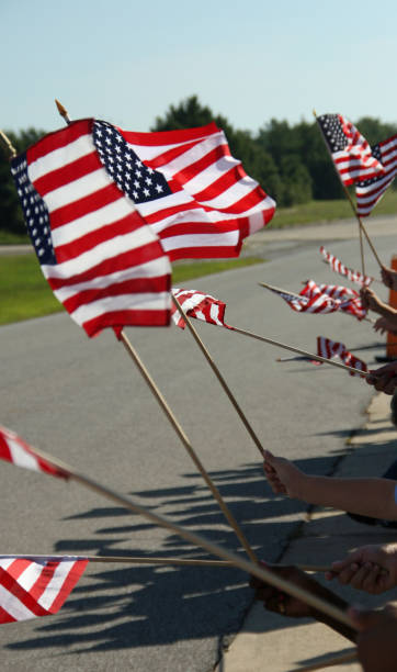 istock American flags waving in the wind sunny day 899250240