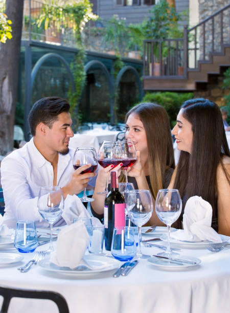 istock Handsome man toasting with two beautiful women. 899251660