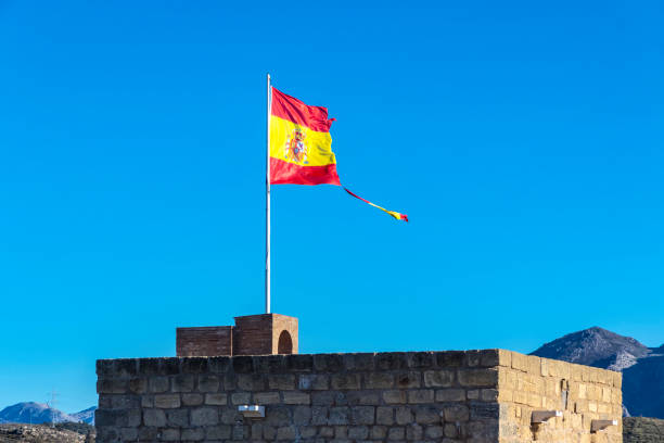 istock Torn Spanish flag waving on the wind 899251974
