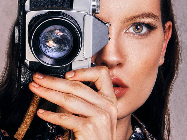 istock Beautiful woman shooting with a retro camera 899256086