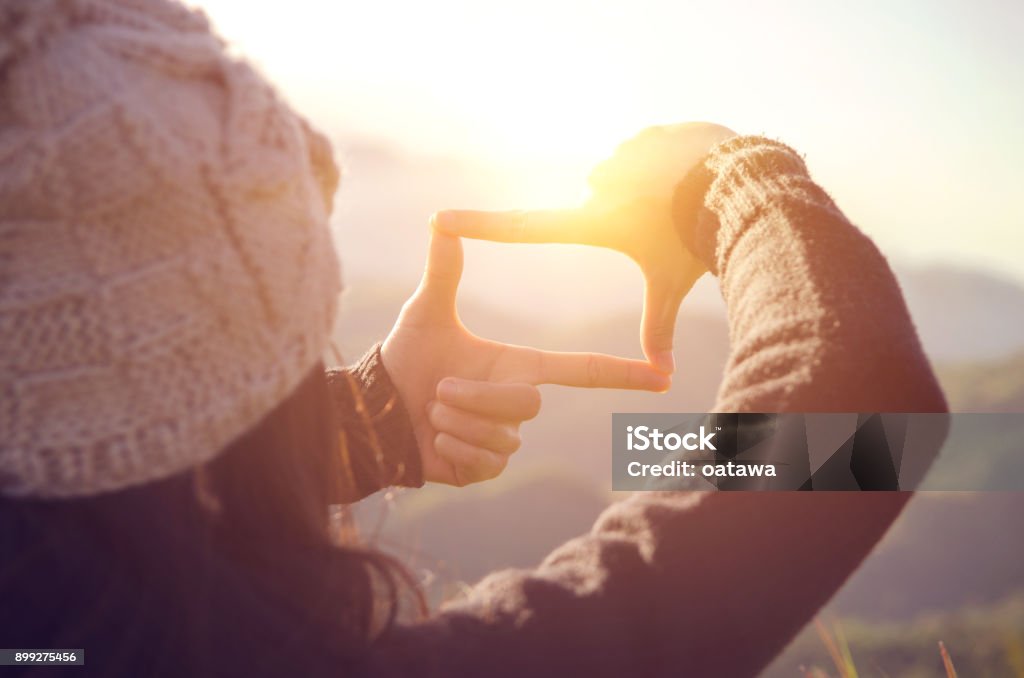 Gros plan des mains de femme cadre geste avec le lever du soleil sur la montagne, femelle capturant le lever du soleil, avenir, planification, lumière du soleil en plein air. - Photo de Idée libre de droits