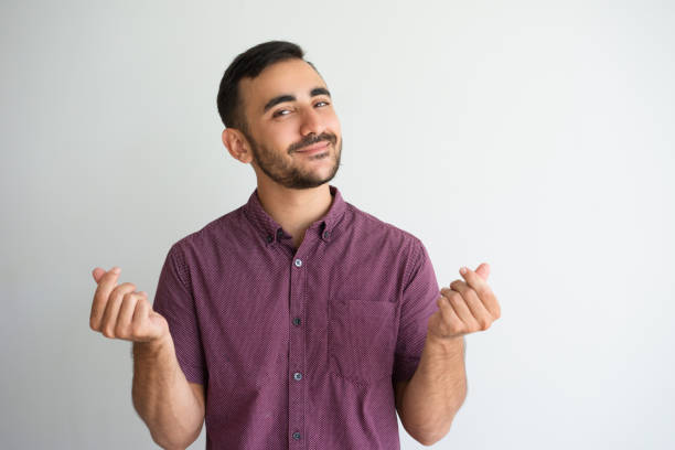 Content Man Rubbing Fingers and Asking for Money Closeup portrait of content man looking at camera, showing money gesture and asking for money. Money concept. Isolated front view on white background. gesturing stock pictures, royalty-free photos & images