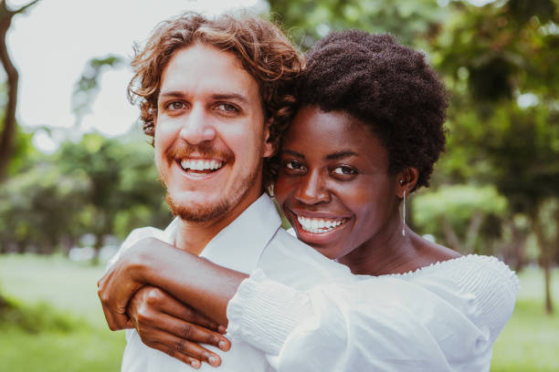 istock Joyful mix-raced couple cuddling in summer park 899288844