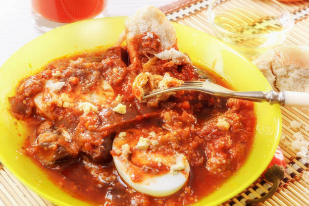 istock Ragout of eggplant and stewed vegetables with boiled eggs. A fork with a piece of egg. Fresh juice and bread 899291960