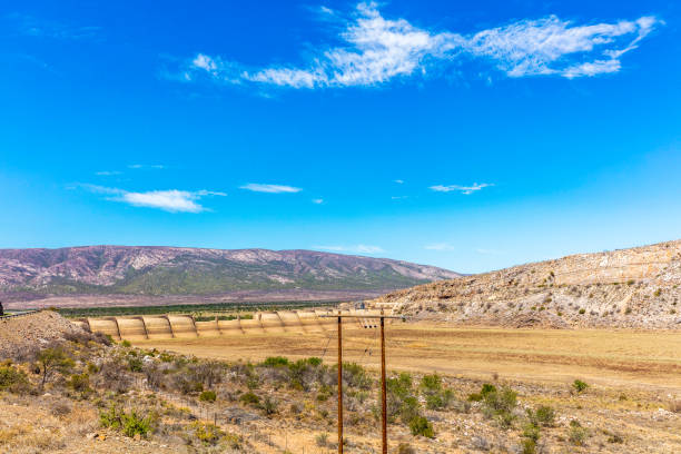 Beervlei dam without water in the karoo, just before Aberdeen with the damwall encatchment to hold any water from the little river.  Outeniqua mountain range seen in the distance.
