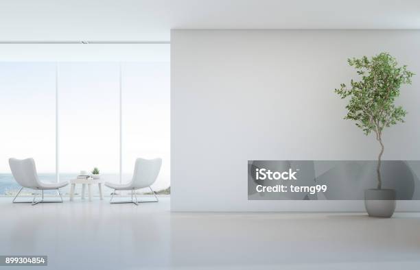 Planta De Interior En El Piso Blanco Con Fondo De Muro De Hormigón Vacía Salón Y Mesa De Centro Junto A La Ventana De Cristal En Mar Vista Salón De Hotel O Casa De Playa De Lujo Moderno Foto de stock y más banco de imágenes de Clínica médica