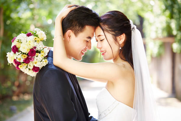 istock youg asian couple hugging on wedding day 899308236
