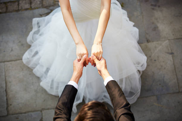 young asian adults dancing in wedding dress young asian newlywed couple wearing wedding dress dancing in open ground, high angle view. chinese wedding dress stock pictures, royalty-free photos & images