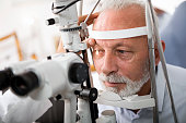 Senior man doing eye test with optometrist