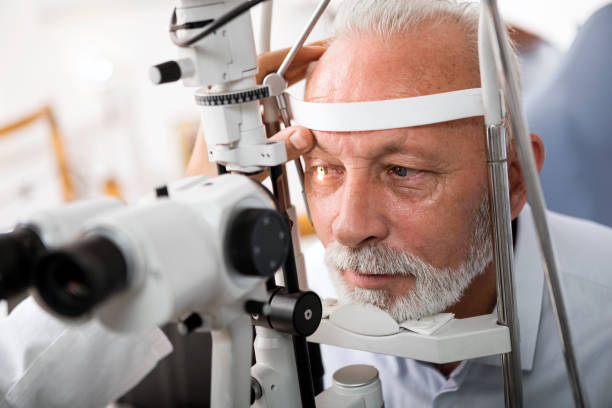 Senior man doing eye test with optometrist stock photo