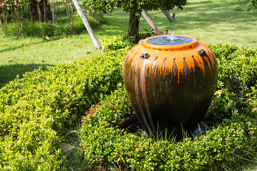 Jar fountain decoration in the green garden.Thailand