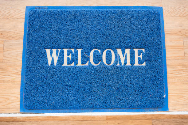 tappetino di benvenuto sullo sfondo del pavimento. - welcome sign doormat greeting floor mat foto e immagini stock