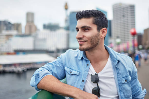 istock Young man looking away while leaning in city 899313990