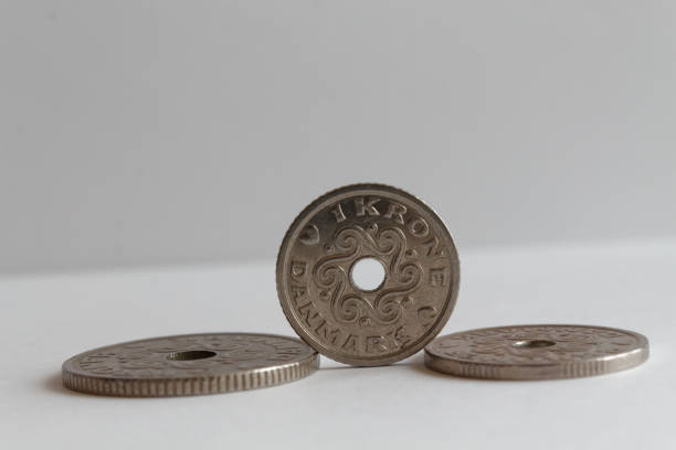 istock Three Denmark coins, front coin denomination is 1 krone (crown) lie on isolated white background 899316404