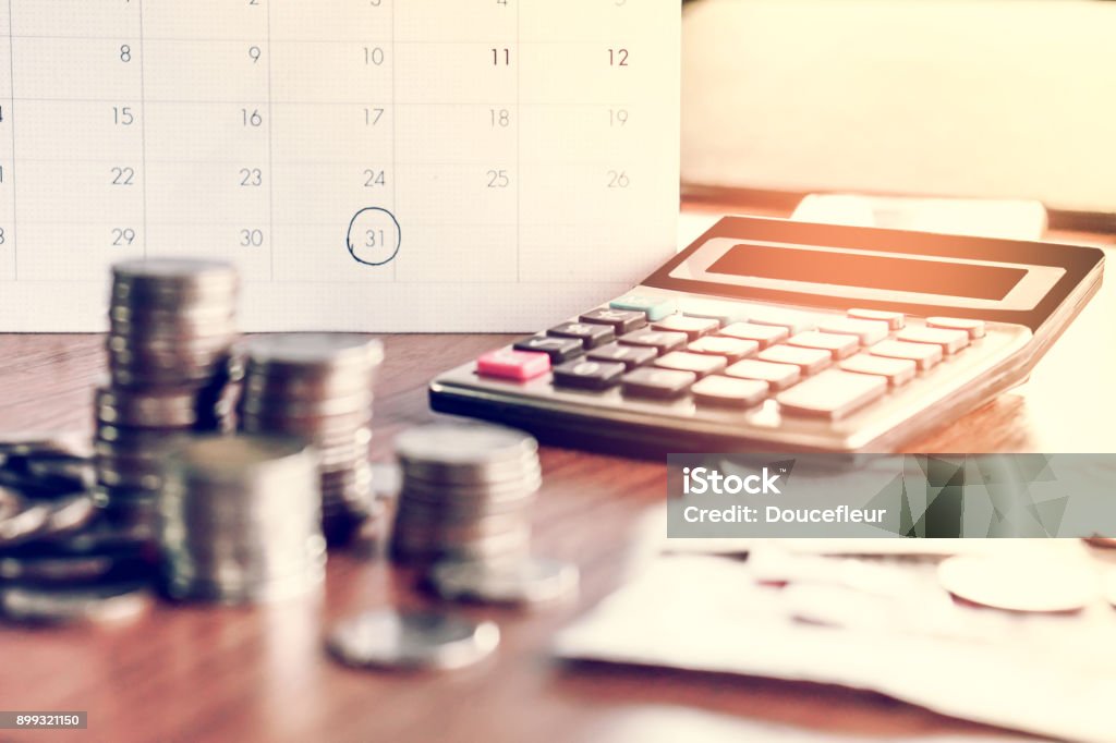 debt collection and tax season concept with deadline calendar remind note,coins,banks,calculator on table debt collection and tax season concept with deadline calendar remind note,coins,banks,calculator on table, background ,time to pay concept Debt Stock Photo