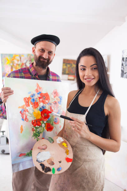 istock Artists presenting flowers painting 899338954