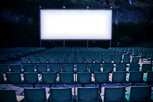 cine al aire libre con pantalla de proyección blanca - imagen tonificada - chair grass flower bed nobody fotografías e imágenes de stock