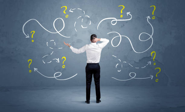 Unsure businessman with question marks A salesman in doubt can not find the solution to the problem concept with curvy lined arrows and question marks drawn on urban wall chaotic stock pictures, royalty-free photos & images