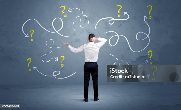 Unsure Businessman With Question Marks Stock Photo - Download Image Now - Lost, Business, Mistake