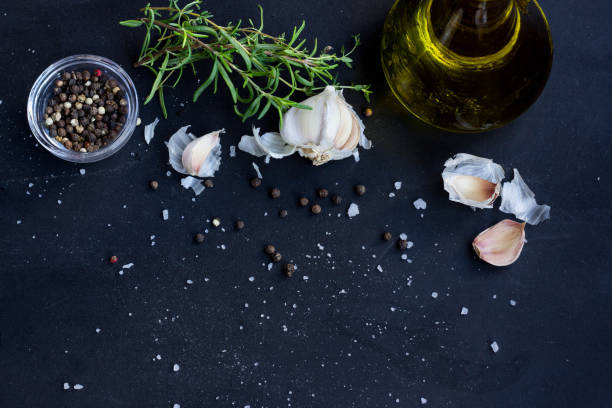 Fresh Herbs, Garlic, Pepper and Olive Oil  on Black Background
