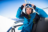 young  snowboarder woman smiling at ski lift