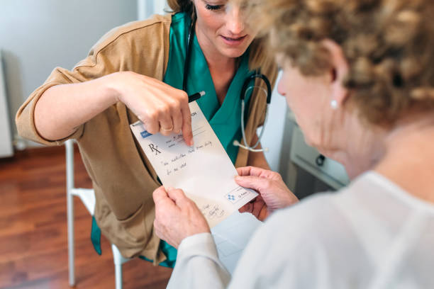 Doctor giving a prescription to senior patient Female doctor giving a prescription to female senior patient pill prescription capsule prescription medicine stock pictures, royalty-free photos & images
