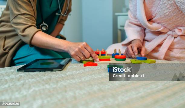 Female Doctor Showing Geometric Shapes To Elderly Patient Stock Photo - Download Image Now