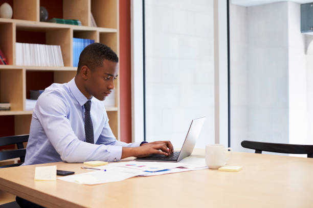 istock Young black businessman working alone in an office, close up 899355104