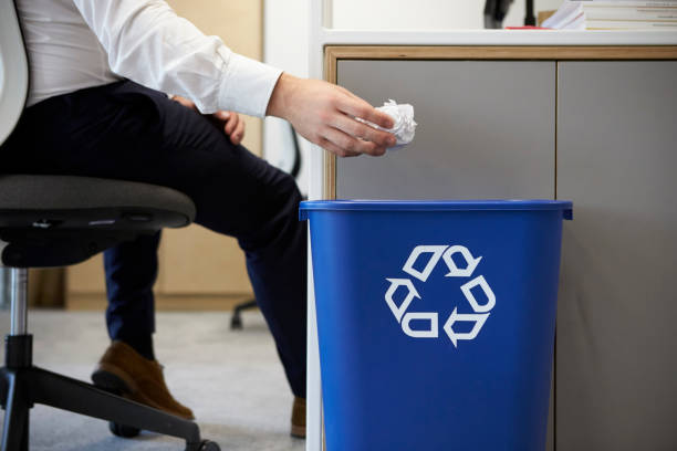 Man dropping screwed up paper into recycling bin, close up Man dropping screwed up paper into recycling bin, close up recycling bin stock pictures, royalty-free photos & images
