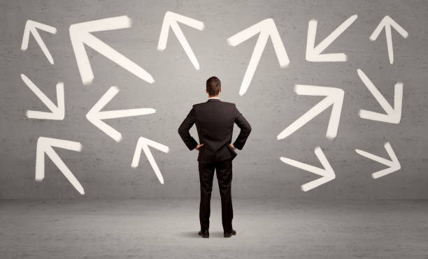istock Confused salesman with arrows on wall 899355348