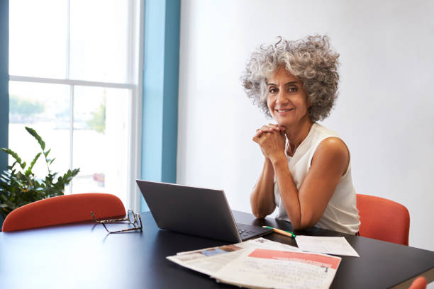istock Middle aged woman working in an office smiling to camera 899355378