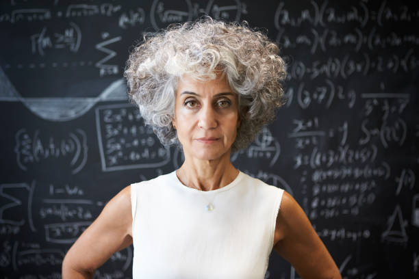 donna accademica di mezza età in piedi davanti alla lavagna - professor teacher female blackboard foto e immagini stock