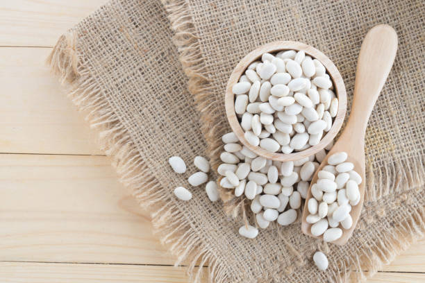 istock white bean in wood cup on sack background 899362858