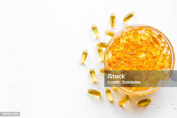 Capsules Of Fish Oil In A Cup On A White Background With Space For Text Stock Photo - Download Image Now