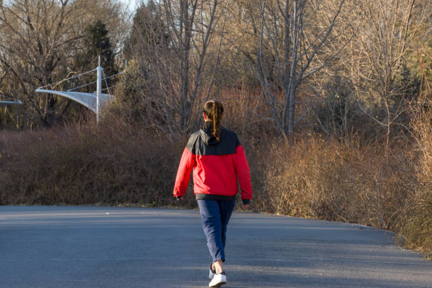 istock Young Woman Walking Amidst Trees 899376874