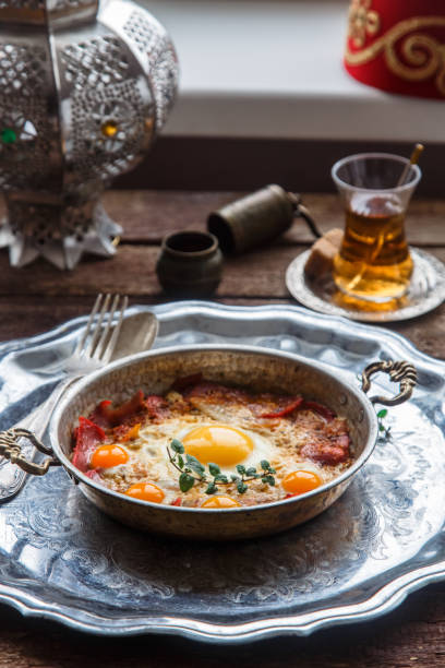 istock Copper pan with fried eggs and sausages, turkish style 899381276