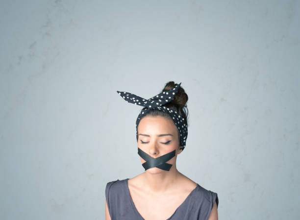 istock Young woman with glued mouth 899385084
