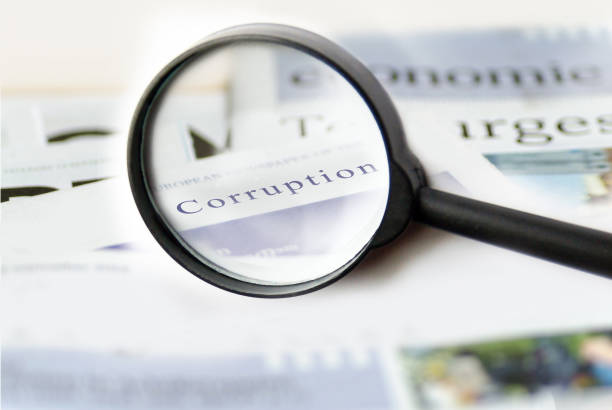 Corruption news concept showing a printed newspaper with a magnifying glass Corruption news concept showing a printed newspaper with a magnifying glass corruption photos stock pictures, royalty-free photos & images