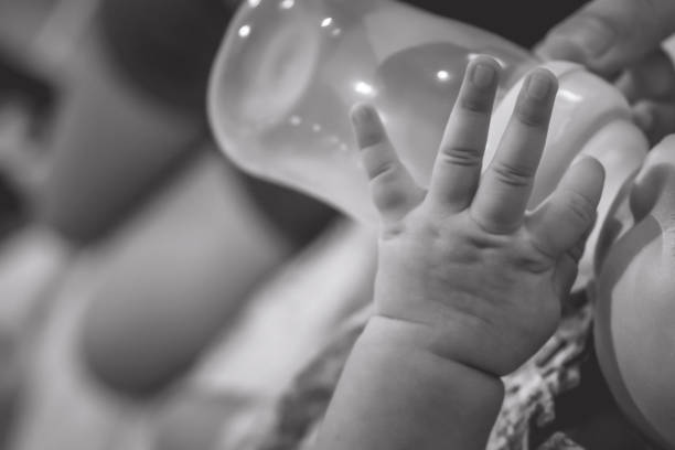 A baby bottle and nurse filled with milk