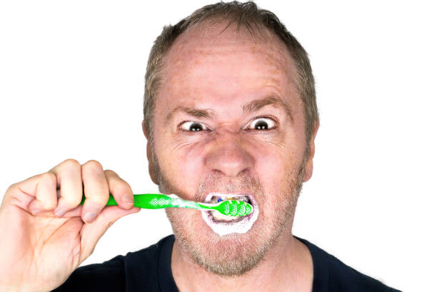 homme furieux se brosser ses dents avec mousse de dentifrice. - furiously photos et images de collection